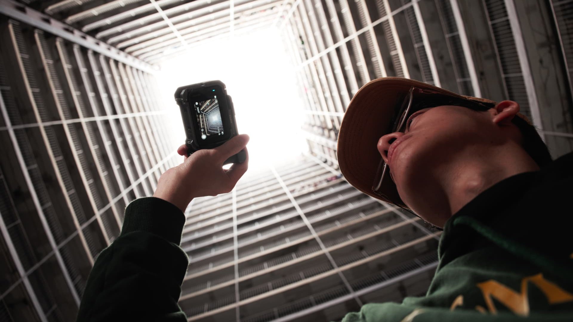 Creator filming upwards in a dim apartment shaft with the Insta360 Ace Pro 2
