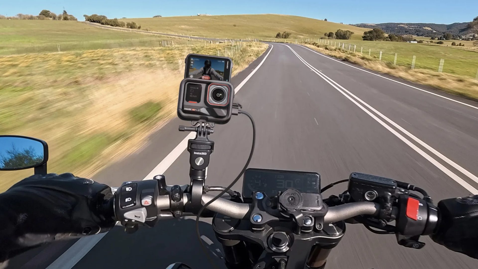 Ace Pro 2 on a motorcycle handlebar mount on an open country road